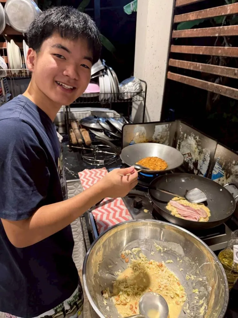 Japanese exchange student cooking Japanese food in a Thai host family kitchen