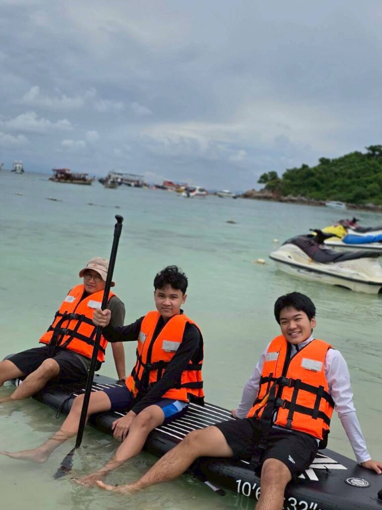 ฮารุมะ และครอบครัวโฮสต์แฟมิลี่ไทย สวมเสื้อชูชีพนั่งบนบอร์ดพายเรือเที่ยวทะเลด้วยกัน
