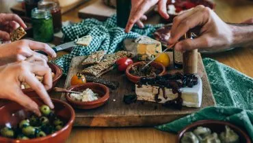 hands picking food on a party table