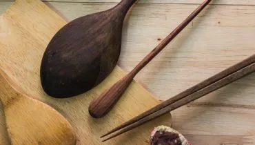 Kitchen utensils on wooden background.