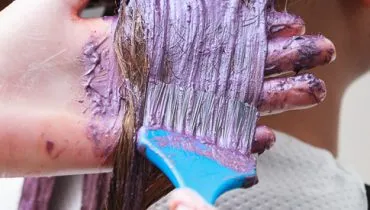 hairdresser applying color female customer at salon, doing hair