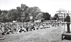 President John F. Kennedy giving a speech to a crowd outside.