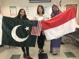 Teacher with students and their country flags in classroom.