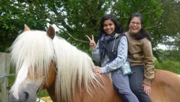 AFS Gastmutter mit Gasttochter auf einem Pferd