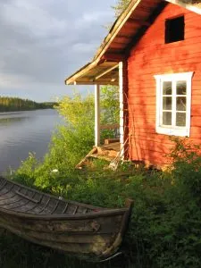 rotes Haus am Wasser bei Sonnenschein in Finnland
