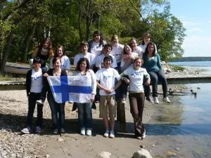 AFSerinnen und AFSer mit finnischer Flagge am Wasser in Finnland