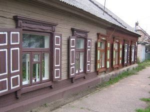 niedrige Häuser mit Klappläden an eine Straße in Lettland