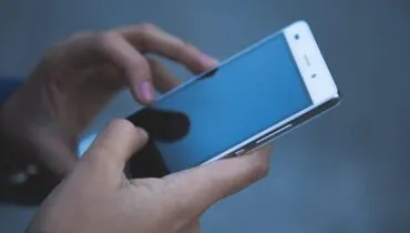 Hände tippen auf einem Smartphone