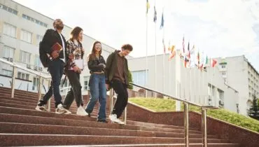 with-education-material-in-hands-four-young-stude-2026-01-08-23-28-59-utc