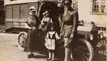 Women and children at St. Amarin, Alsace, gave flowers to A. Piatt Andrew., ca. 1915