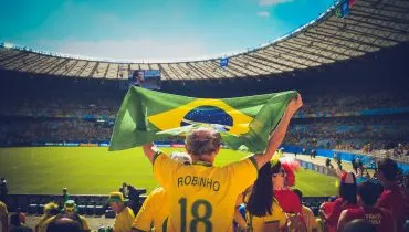 Canva – Man Raising Brazil Flag Inside Football Stadium_edited