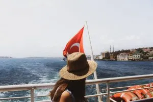 Canva – Woman Wearing Brown Sun Hat Near Turkey Flag and Body of Water_edited