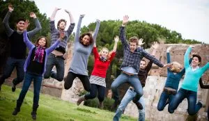 Group of Happy College Students Jumping at Park