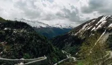 Beautiful snowy Swiss Alps mountains and curve track in summer time