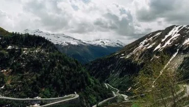 Beautiful snowy Swiss Alps mountains and curve track in summer time