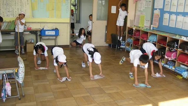 Niños limpiando el aula tras la jornada escolar en Japón